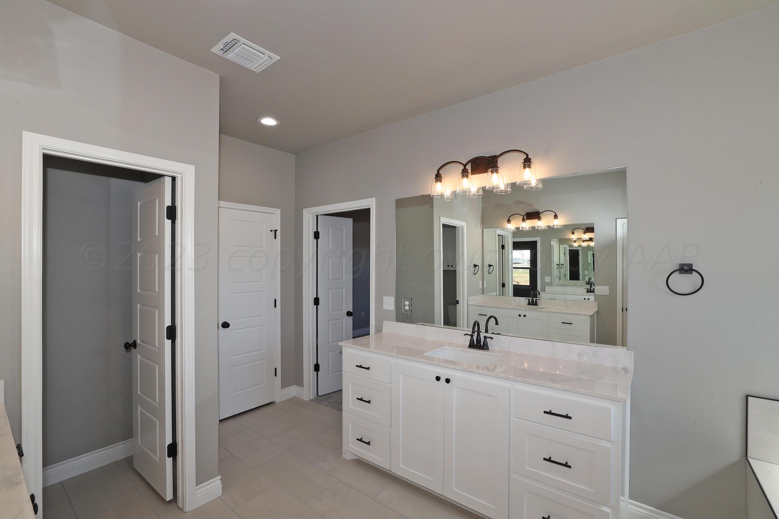 9551 Trinity Drive Amarillo, TX 79119 - Photo 18 of 46 a bathroom with a double vanity sink and a mirror