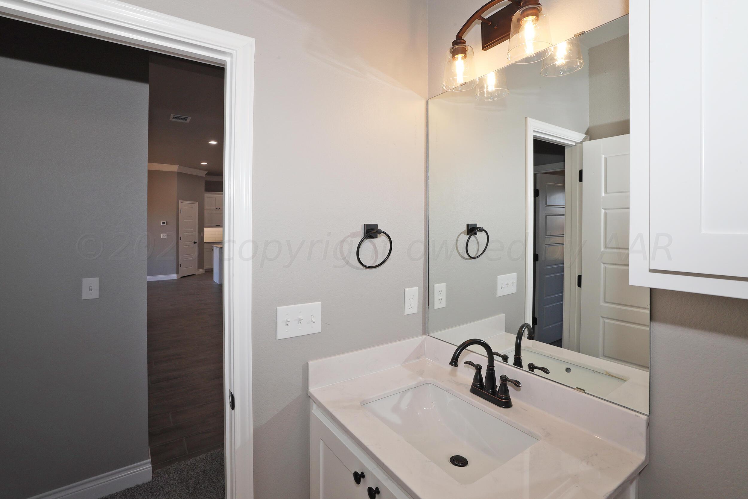 9551 Trinity Drive Amarillo, TX 79119 - Photo 27 of 46 a bathroom with a sink and mirror