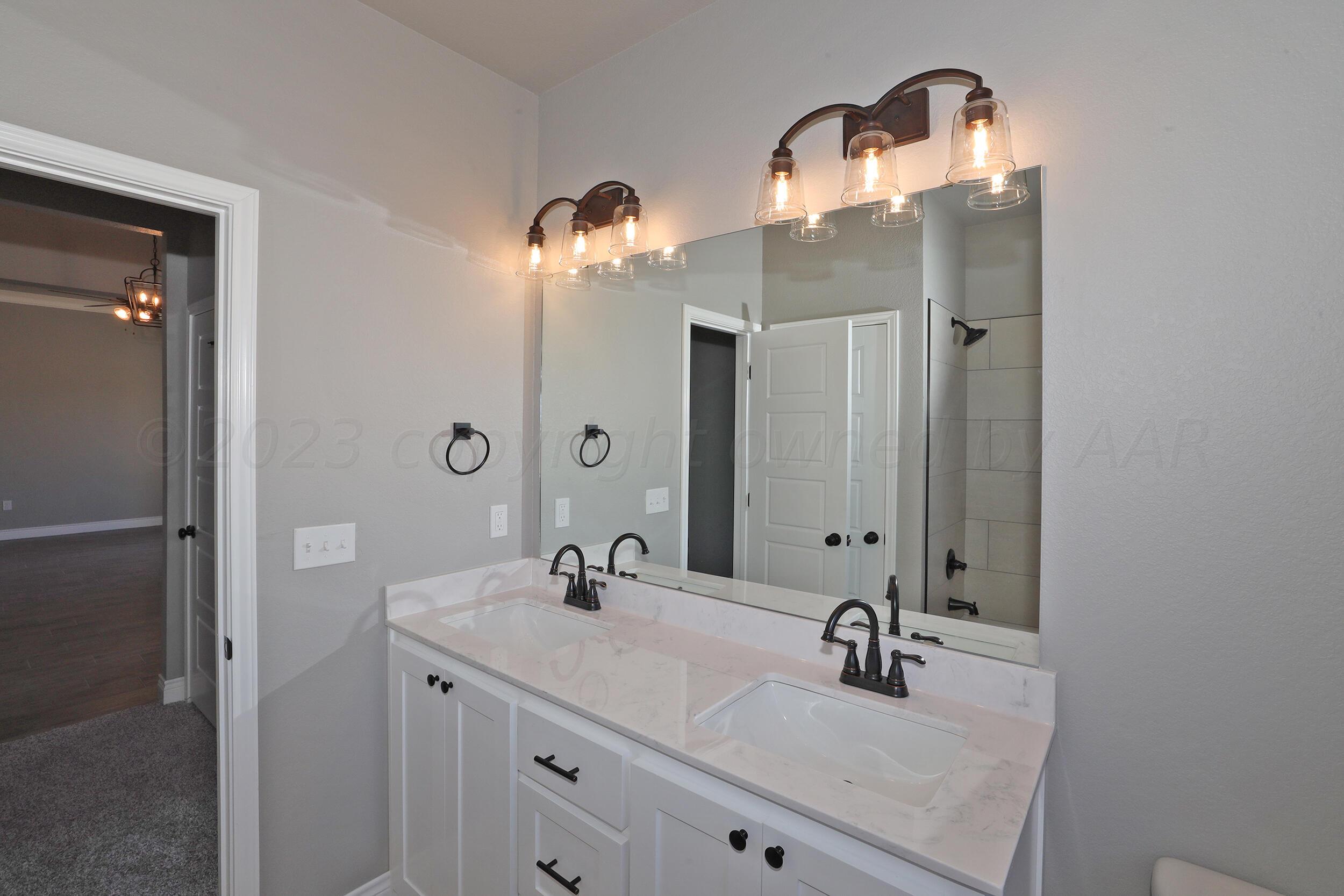 9551 Trinity Drive Amarillo, TX 79119 - Photo 28 of 46 a bathroom with a double vanity sink and mirror
