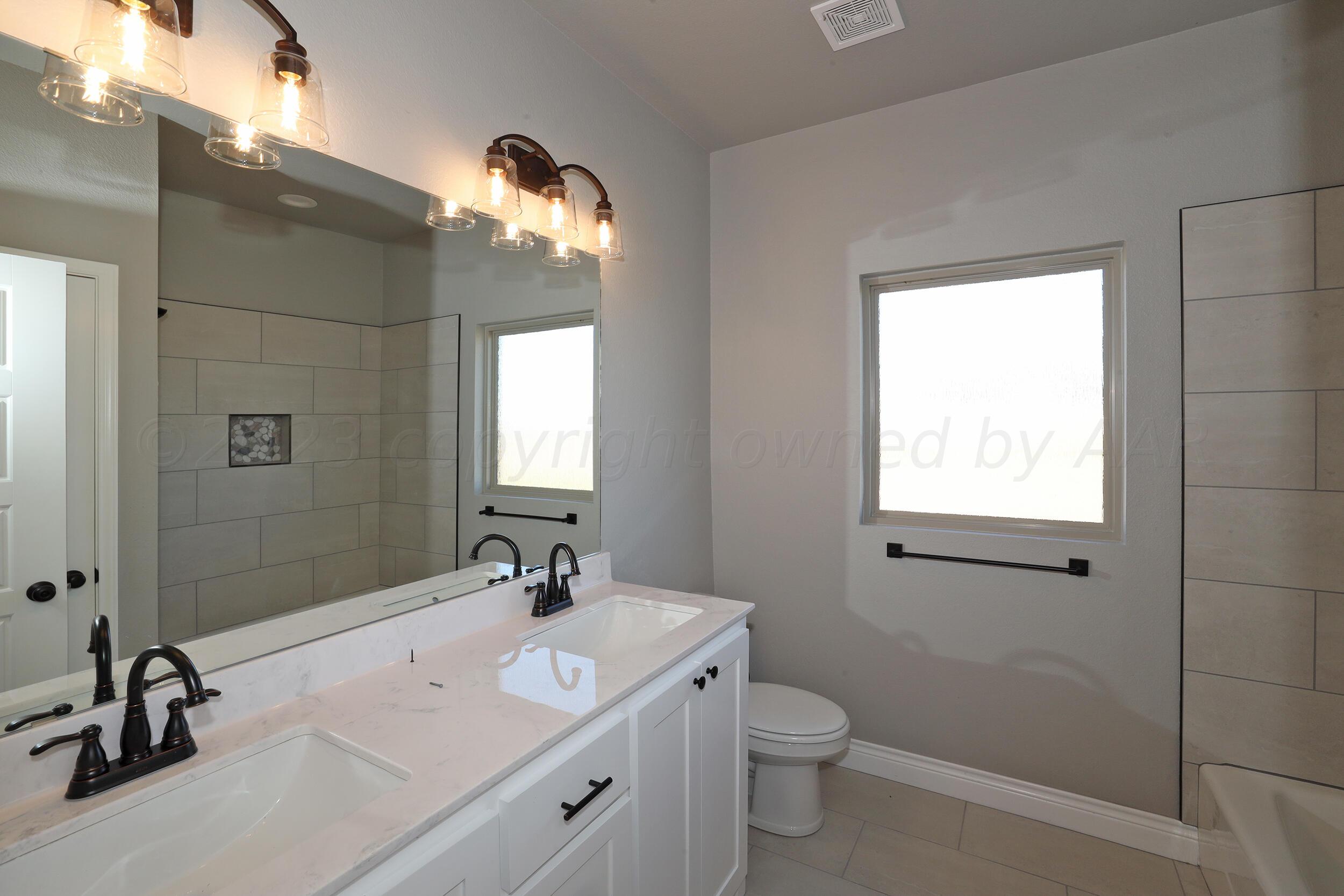 9551 Trinity Drive Amarillo, TX 79119 - Photo 29 of 46 a bathroom with a double vanity sink and a mirror