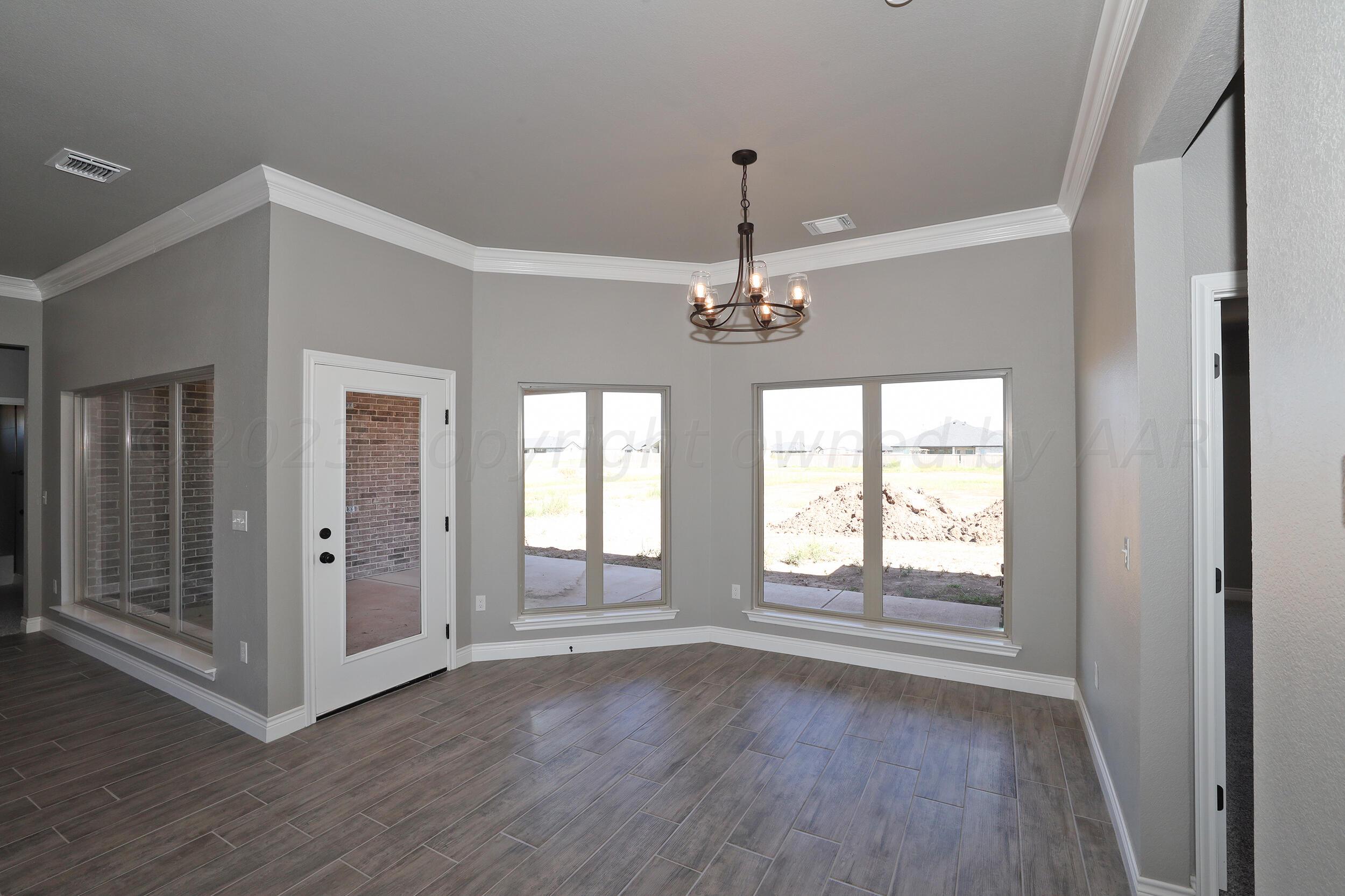9551 Trinity Drive Amarillo, TX 79119 - Photo 30 of 46 a view of an empty room with wooden floor and a window