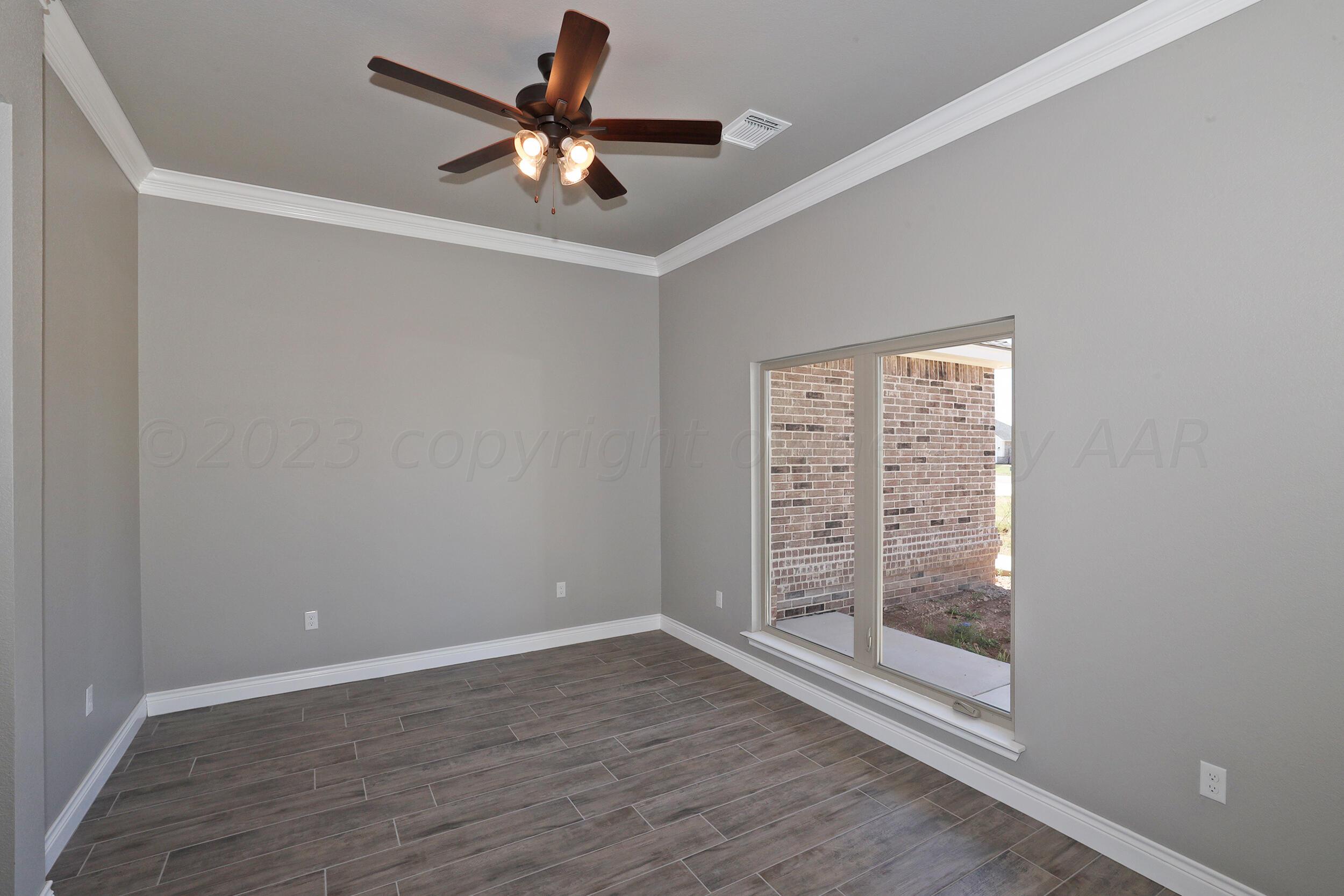 9551 Trinity Drive Amarillo, TX 79119 - Photo 34 of 46 an empty room with wooden floor fan and windows