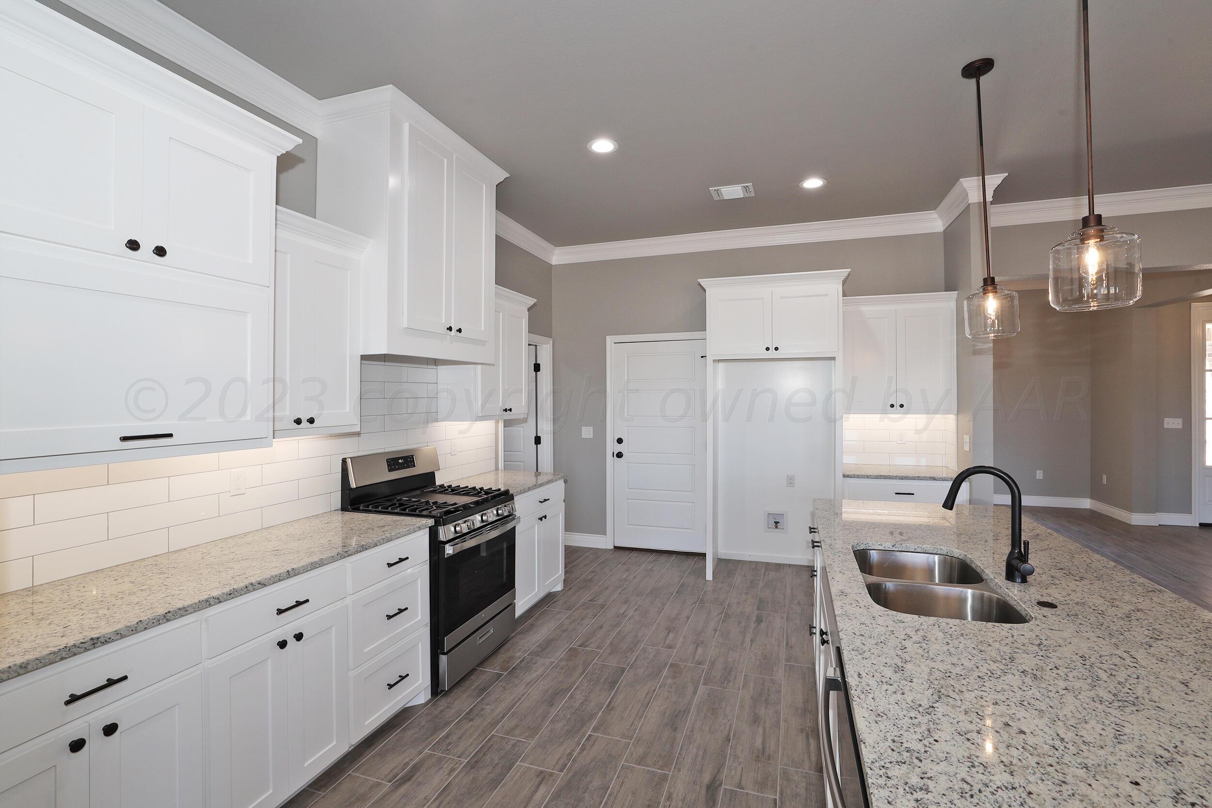 9551 Trinity Drive Amarillo, TX 79119 - Photo 37 of 46 a kitchen with granite countertop a sink stainless steel appliances and cabinets