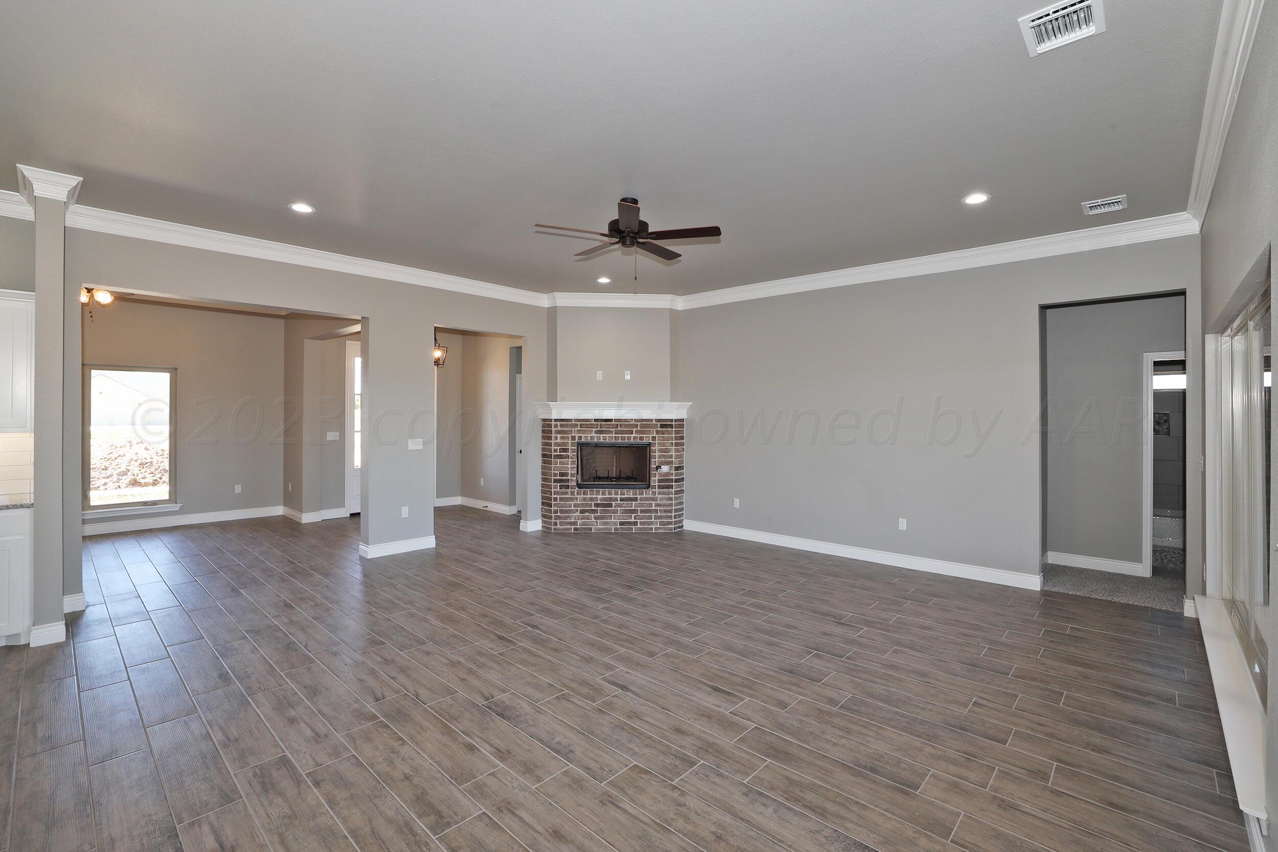 9551 Trinity Drive Amarillo, TX 79119 - Photo 5 of 46 a view of a livingroom with wooden floor and a ceiling fan