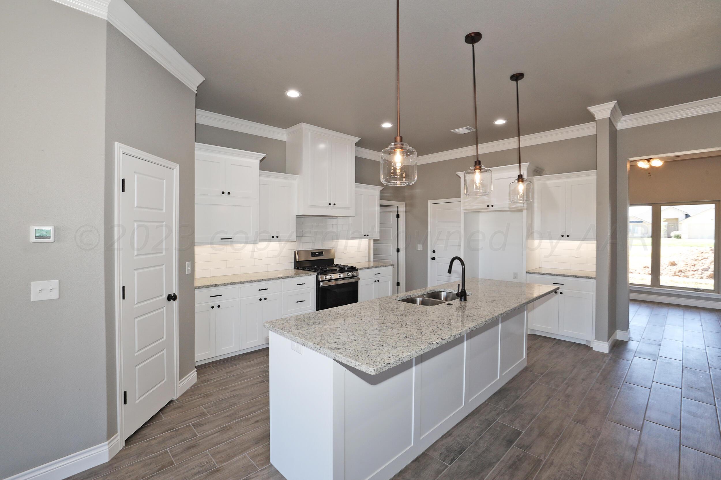 9551 Trinity Drive Amarillo, TX 79119 - Photo 6 of 46 a large kitchen with stainless steel appliances kitchen island granite countertop a sink and refrigerator