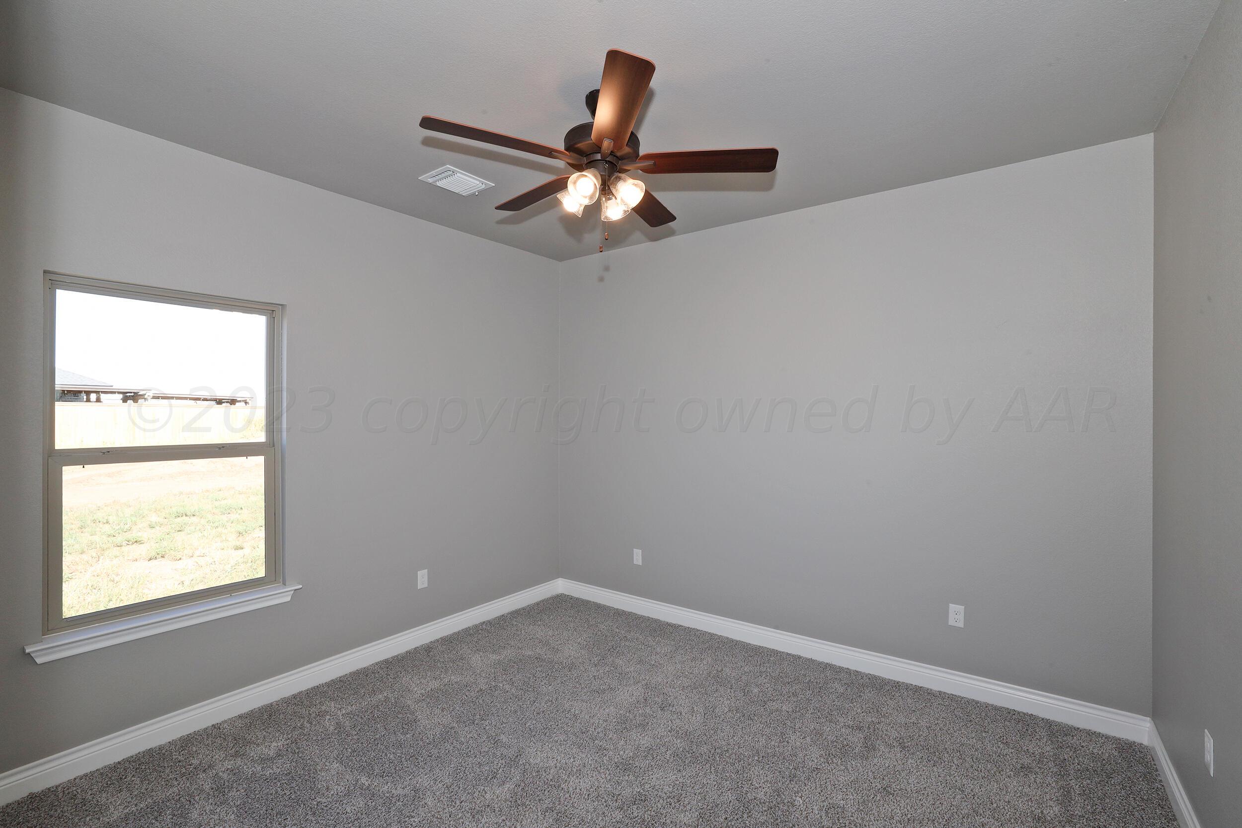 9551 Trinity Drive Amarillo, TX 79119 - Photo 8 of 46 an empty room with windows and fan