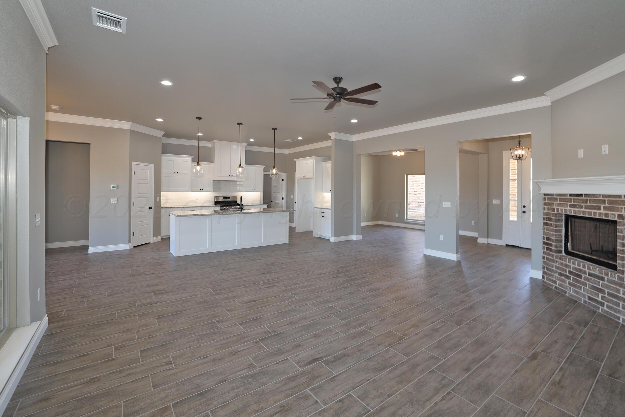 9551 Trinity Drive Amarillo, TX 79119 - Photo 9 of 46 a large kitchen with cabinets and wooden floor