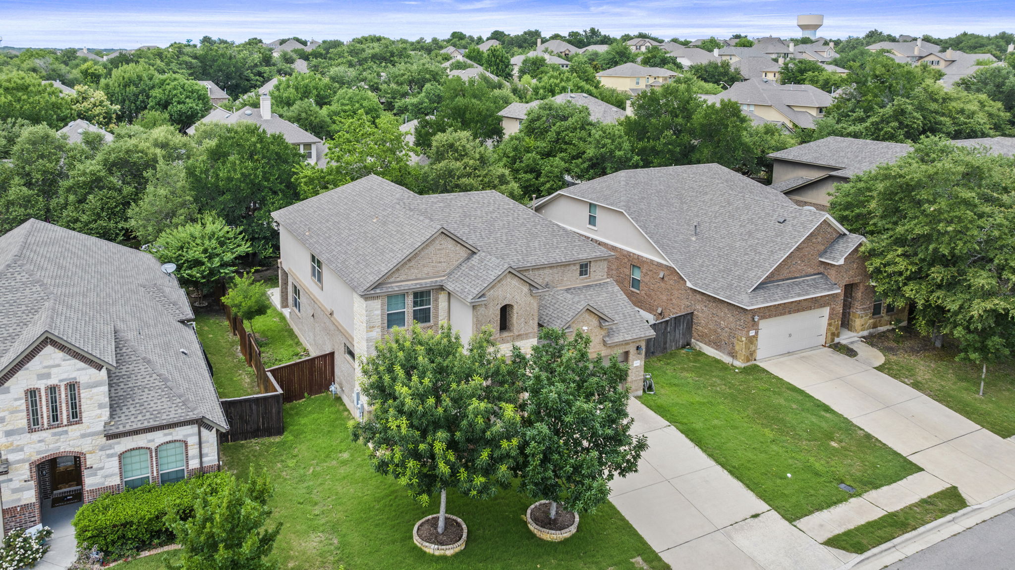 4401 Trinity Woods Street Leander, TX 78641 - Photo 36 of 37 Two-story residence with a classic brick and stone facade and a manicured front lawn.