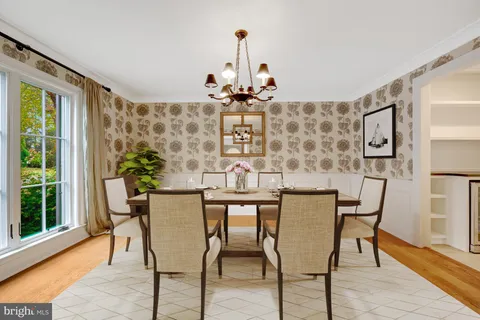 a kitchen with stainless steel appliances granite countertop a stove top oven a refrigerator a sink and white cabinets with wooden floor