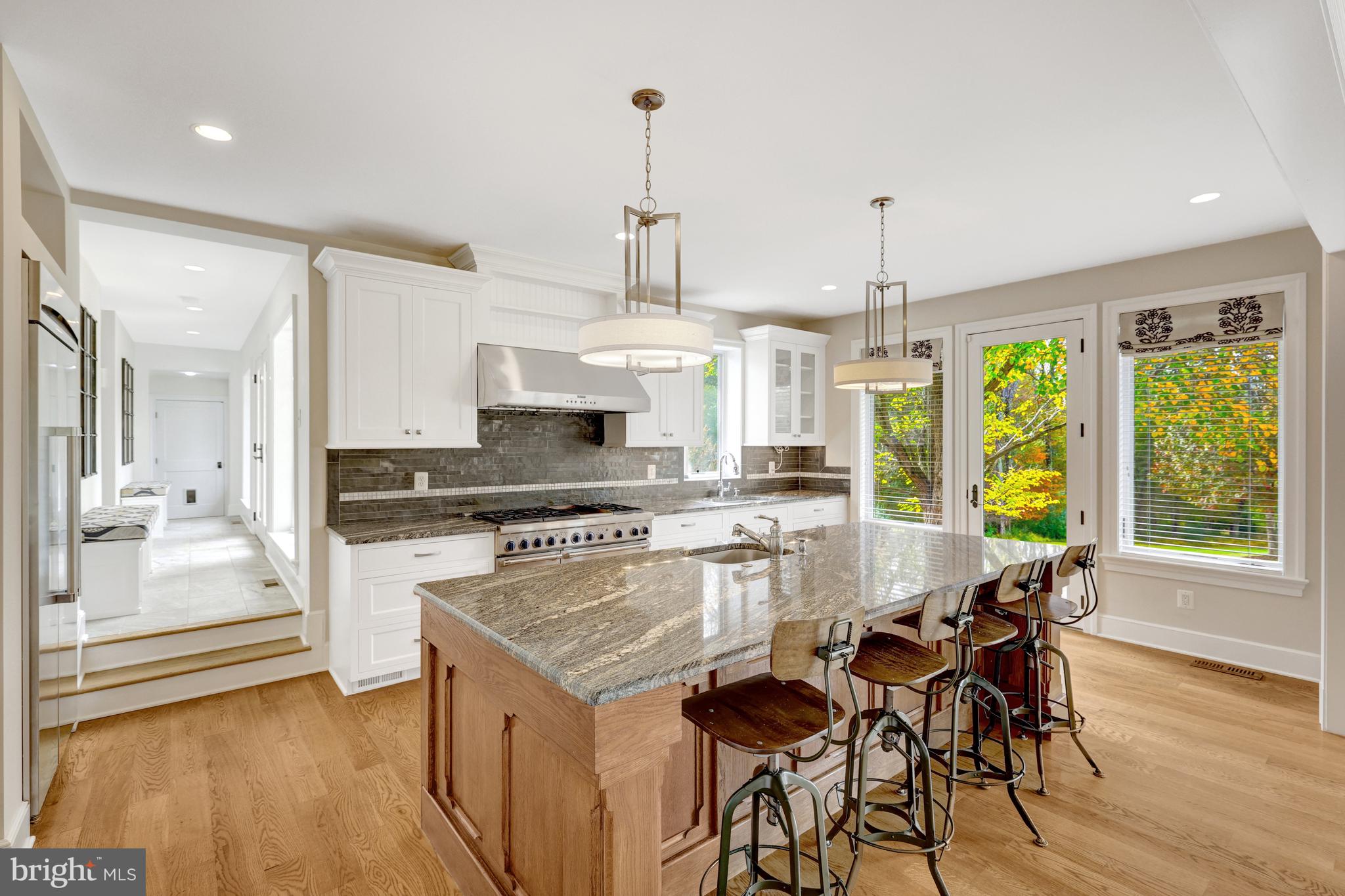 440 Montpelier Road Great Falls, VA 22066 - Photo 17 of 79 a kitchen with stainless steel appliances granite countertop a stove top oven a refrigerator a sink and white cabinets with wooden floor