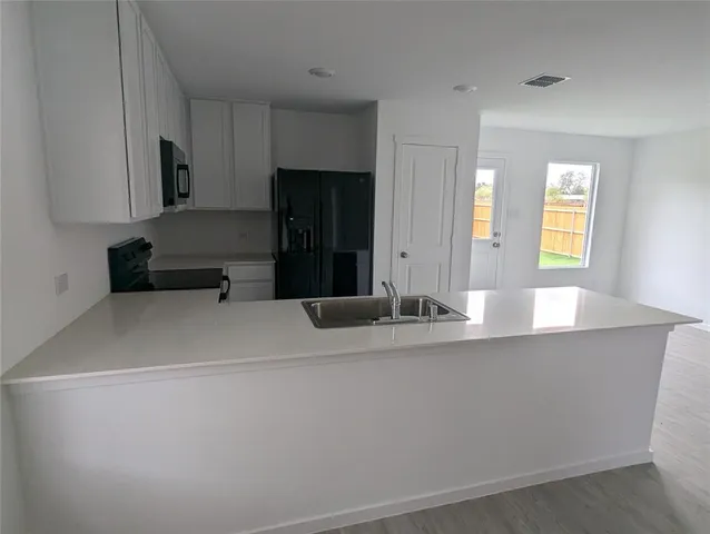 a view of empty room with wooden floor and fireplace