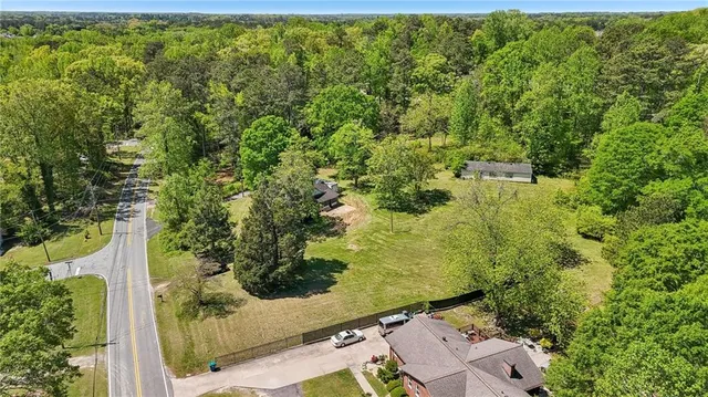 a view of a house with a lush green forest