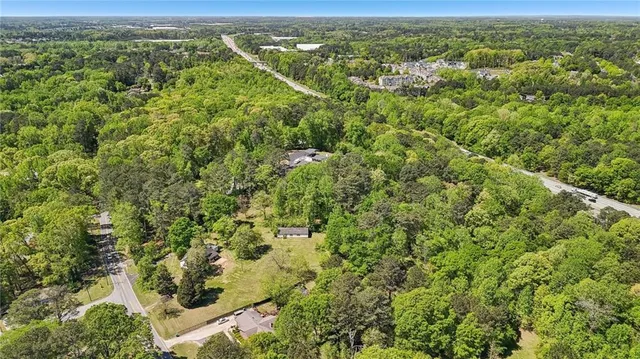an aerial view of residential houses with outdoor space and trees