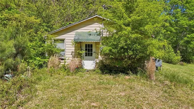 a front view of a house with a yard and trees