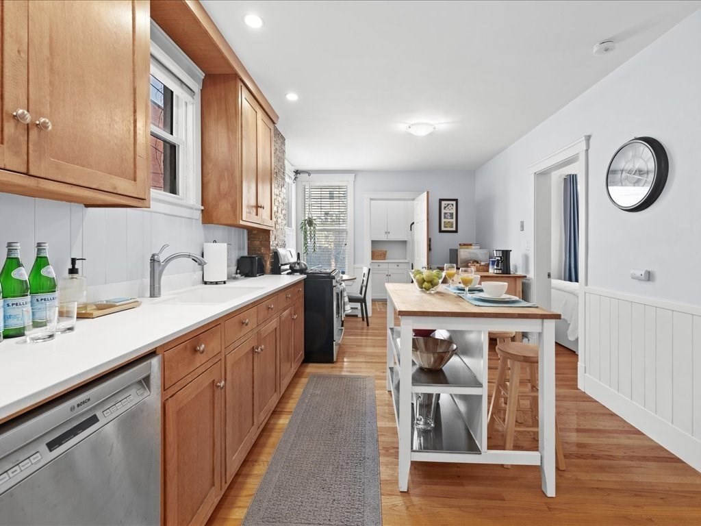 556 East 5th Street, Unit 1 Boston, MA 02127 - Photo 6 of 17 a kitchen with kitchen island granite countertop a sink cabinets and stainless steel appliances