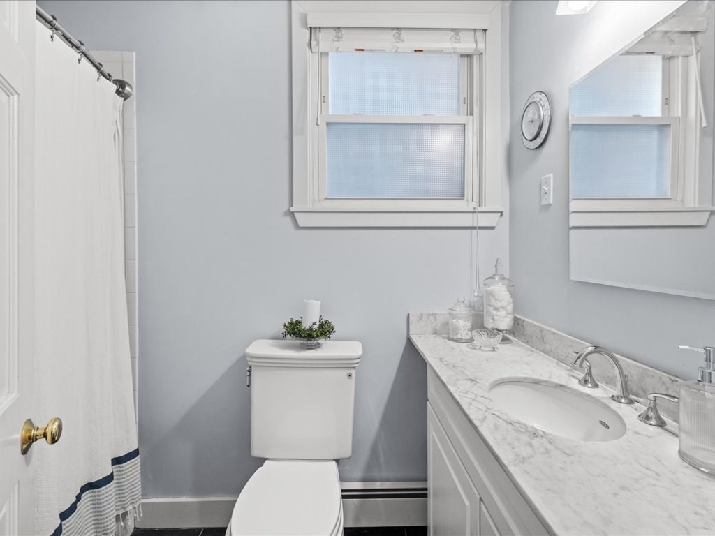 556 East 5th Street, Unit 1 Boston, MA 02127 - Photo 9 of 17 a bathroom with a granite countertop toilet a sink and a mirror