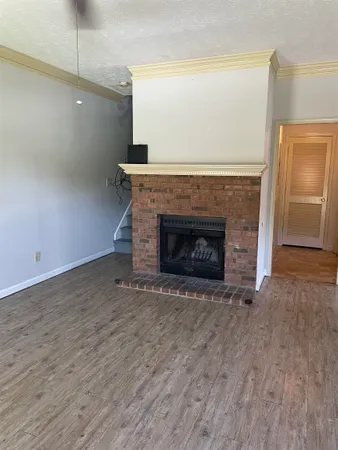 a view of empty room with wooden floor and fireplace