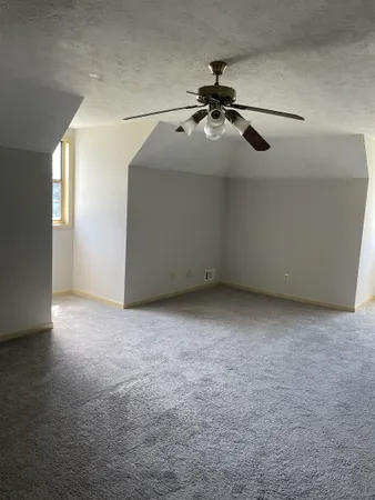 en empty room with windows and fan