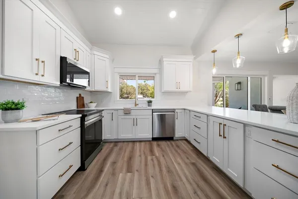 a kitchen with a white cabinets sink and stainless steel appliances