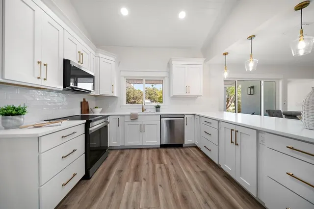 a kitchen with a white cabinets sink and stainless steel appliances