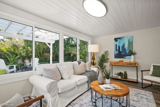 a living room with furniture a table and a large window