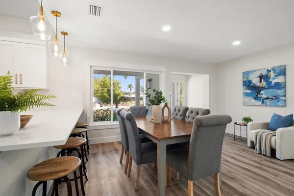 a dining room with furniture a window and wooden floor