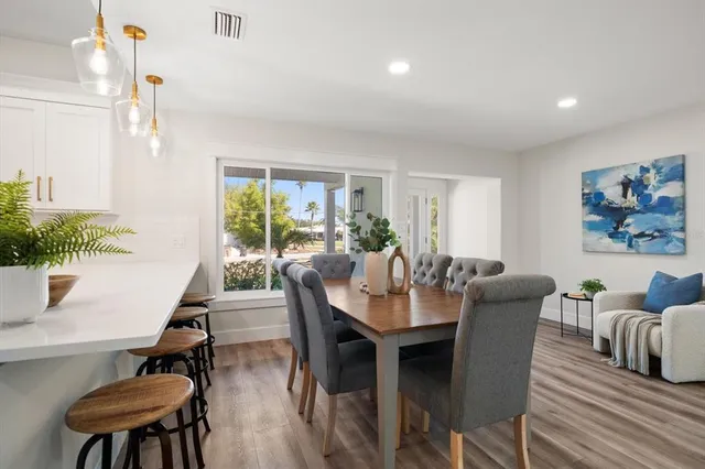 a dining room with furniture a window and wooden floor