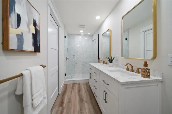 a bathroom with a double vanity sink mirror and shower