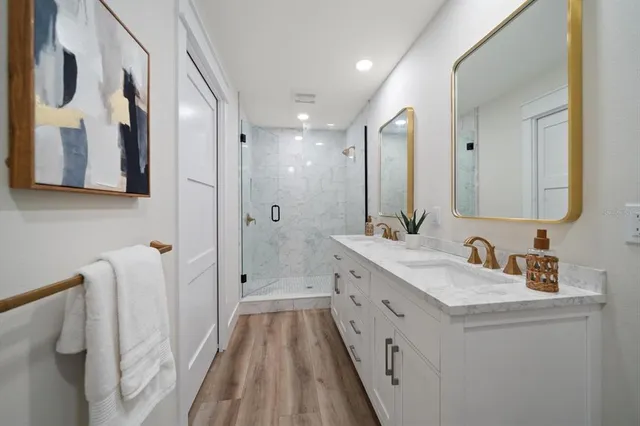 a bathroom with a double vanity sink mirror and shower