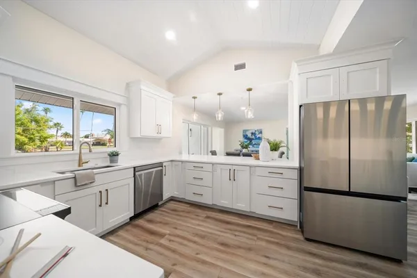 a large kitchen with white cabinets and stainless steel appliances