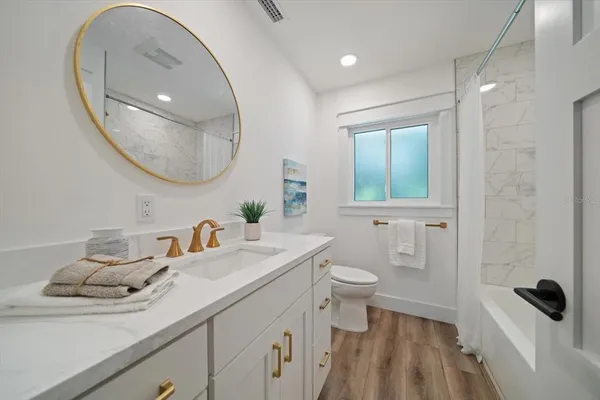 a bathroom with a sink a toilet and a mirror