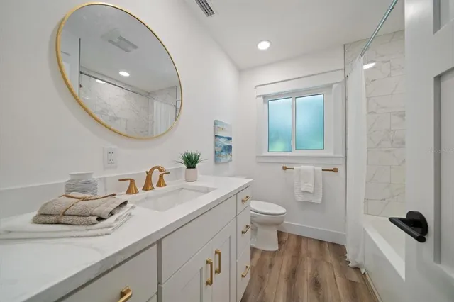 a bathroom with a sink a toilet and a mirror