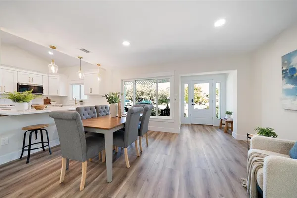 a living room with furniture dining table and a large window