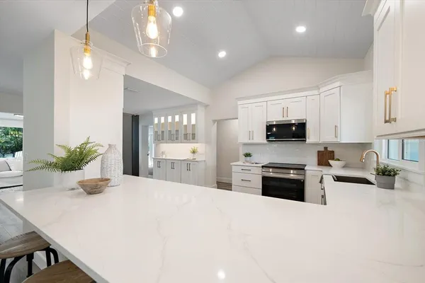 a kitchen with stainless steel appliances a stove sink microwave and cabinets
