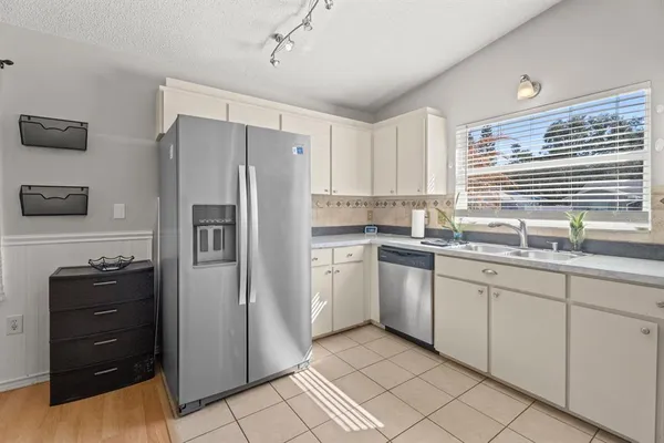 a kitchen with granite countertop a refrigerator and a sink
