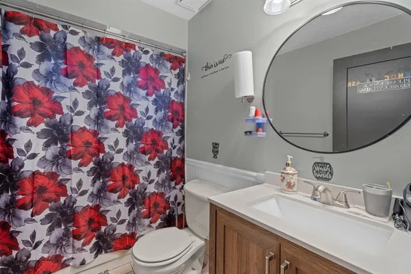 a bathroom with a sink vanity mirror and toilet