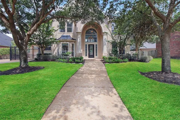 a front view of a house with a yard and trees