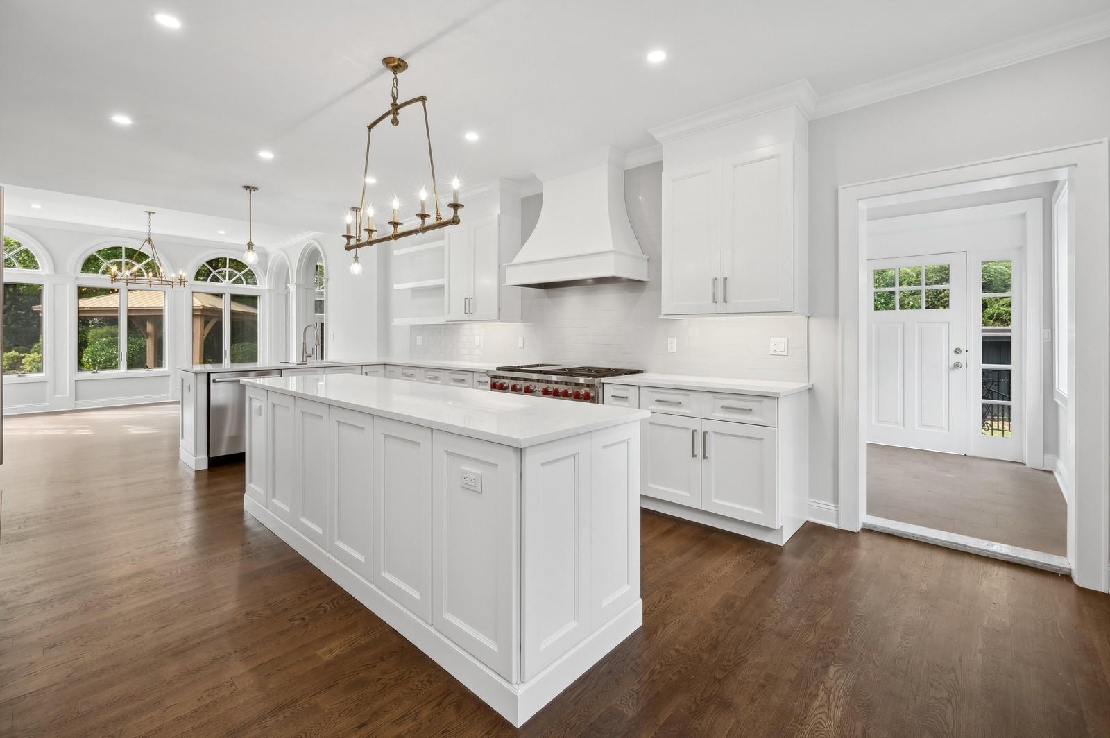 45 Durham Road Bronxville, NY 10708 - Photo 15 of 25 Kitchen featuring hanging light fixtures, white cabinetry, custom range hood, and kitchen peninsula