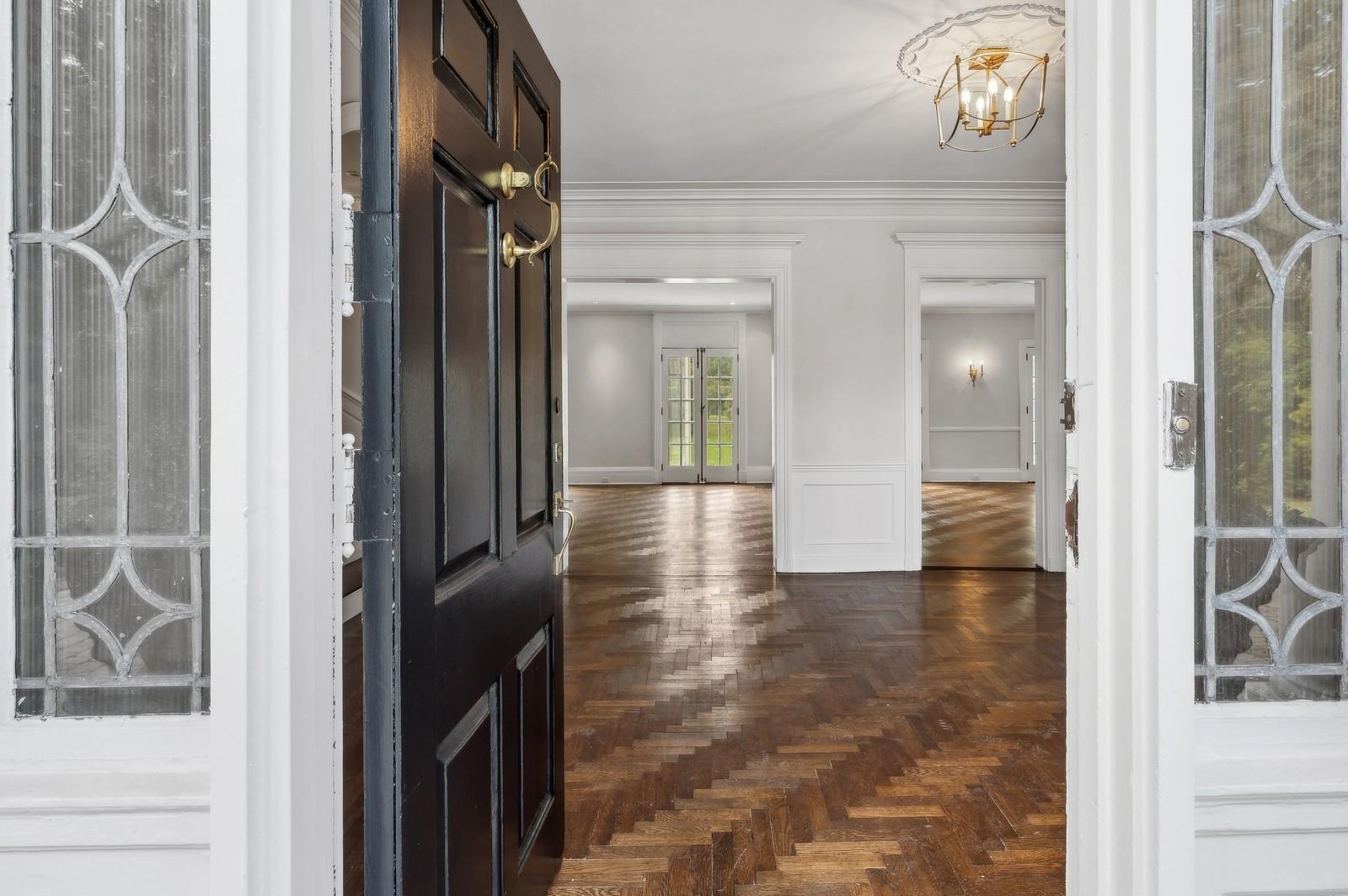 45 Durham Road Bronxville, NY 10708 - Photo 6 of 25 Entrance foyer featuring ornamental molding, an inviting chandelier, and dark parquet flooring