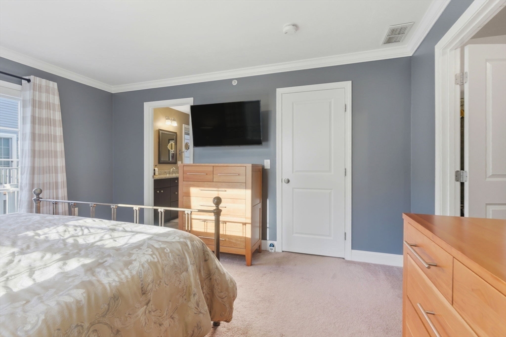 66 Compass Point, Unit 66 North Andover, MA 01845 - Photo 31 of 42 a bedroom with a bed and a flat screen tv