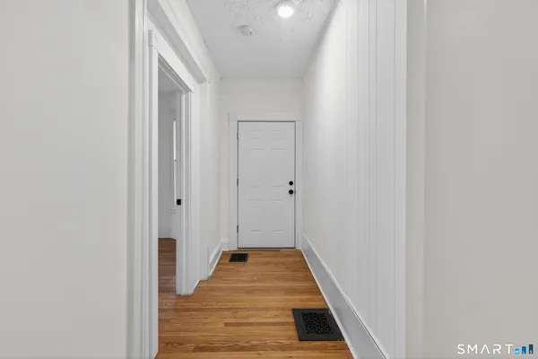 a view of a hallway with wooden floor and staircase