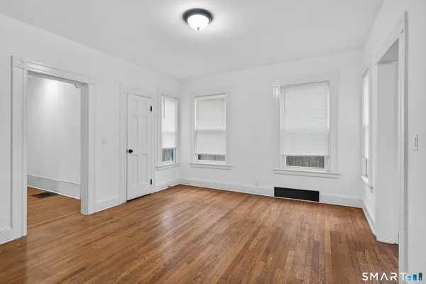 a view of empty room with wooden floor