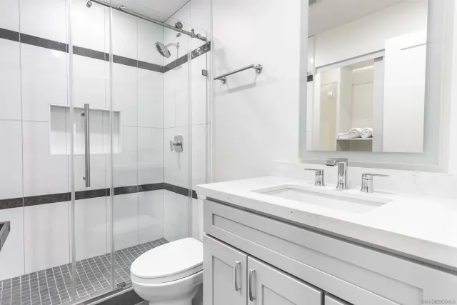 a bathroom with a sink a toilet and shower