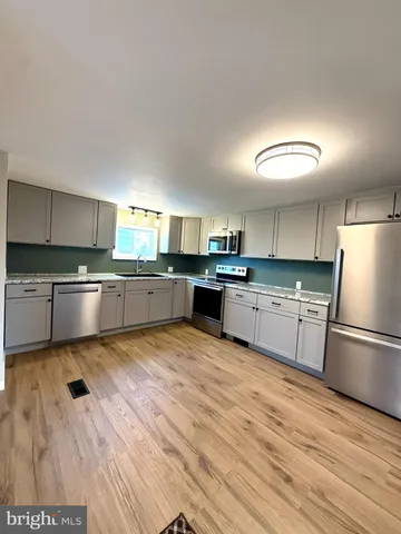 a large kitchen with cabinets and stainless steel appliances