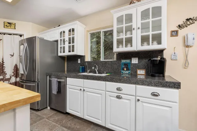 a kitchen with stainless steel appliances granite countertop a sink and a refrigerator