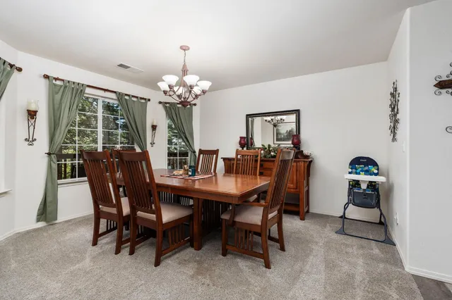 a dining room with furniture a chandelier and a rug