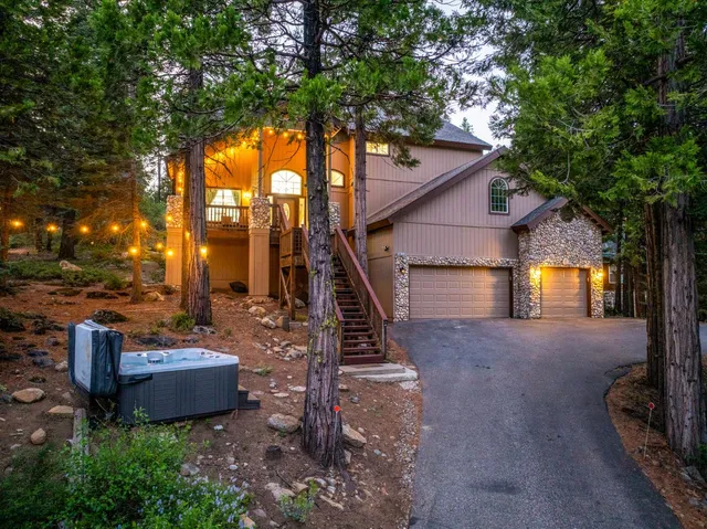 a front view of a house with garden and trees