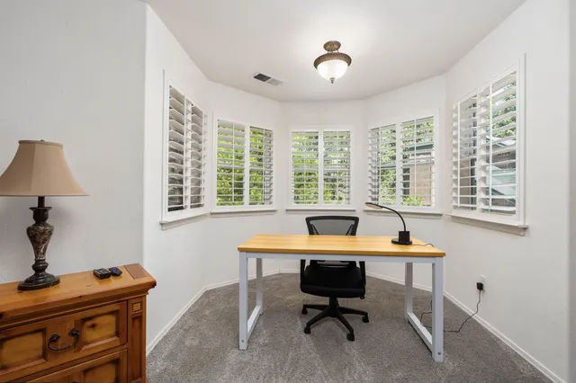 a view of a workspace with furniture and a window