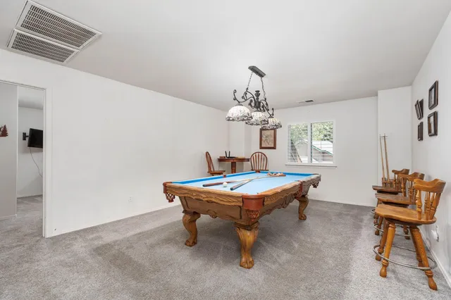 a room with pool table and windows