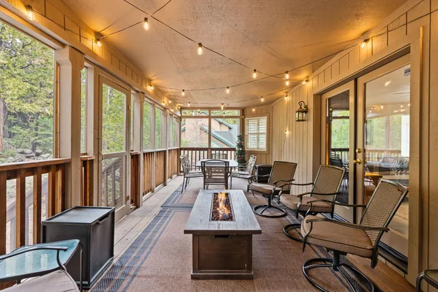 a living room with hardwood floor and large windows